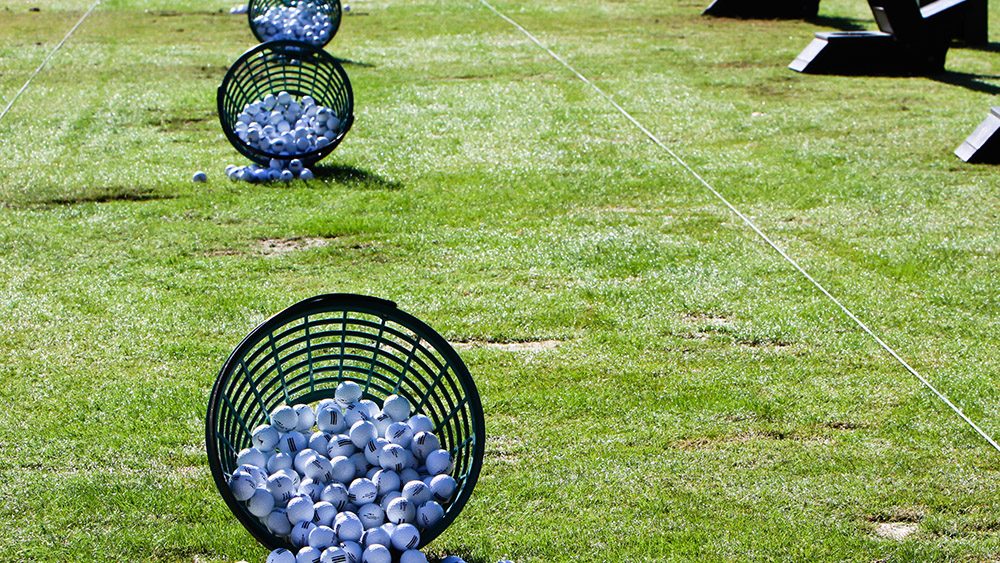 A bucket of practice balls at golf driving range.